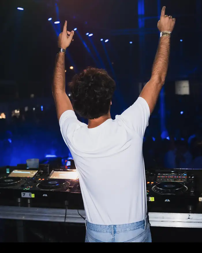 DJ con los brazos en alto frente a la pista en un evento de Bongala Studio